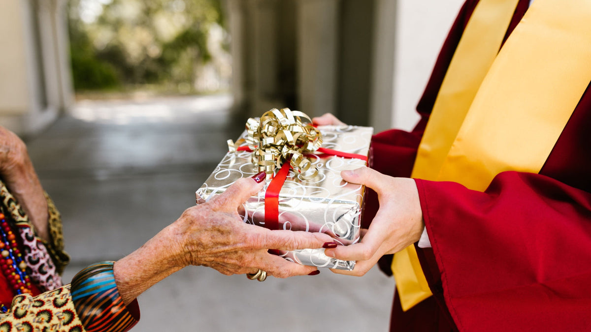 A person giving a beautifully wrapped gift to someone, celebrating the joy of thoughtful giving.