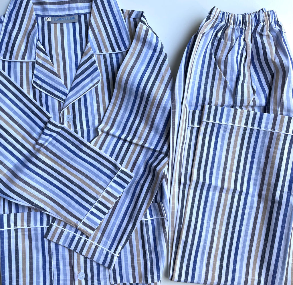 A two-piece pajama set laid flat on a light background, featuring a long-sleeve button-up shirt and matching pants. The fabric has a vertical stripe pattern in shades of blue, navy, brown, and white.