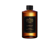 An amber brown bottle of Charm Aroma Natural fragrance with a black cap and a black label with gold lettering, set against a plain white background.