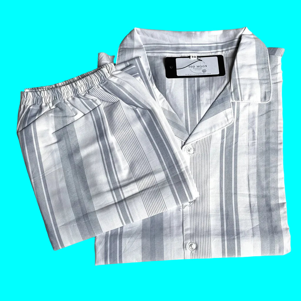 A folded two-piece pajama set with a matching button-front long-sleeve shirt and elastic-waist shorts, both in a white and gray striped pattern, laid flat on a light background. Labelled TED MOON