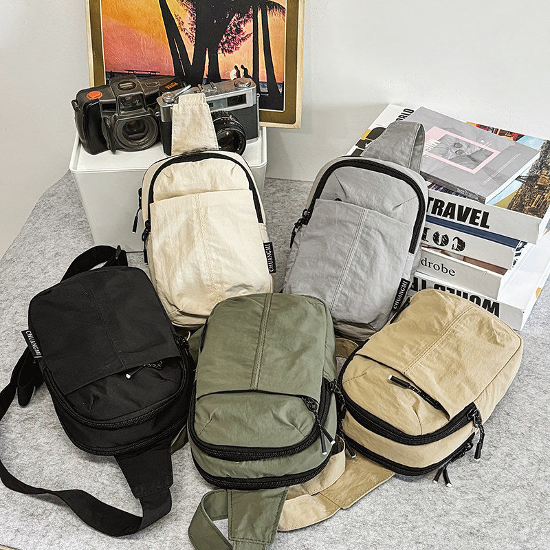 Five minimalist crossbody sling bags in black, cream, gray, olive green, and tan. Suitable for casual outings, commuting, travel and leisure activities.