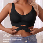 A woman wearing a black supportive bra with a crossover lifting strap and buckle, shown from the chest to the hips with text overlay instructions on how to adjust the strap.