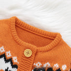 Close-up of an orange knit cardigan sweater with a gold button