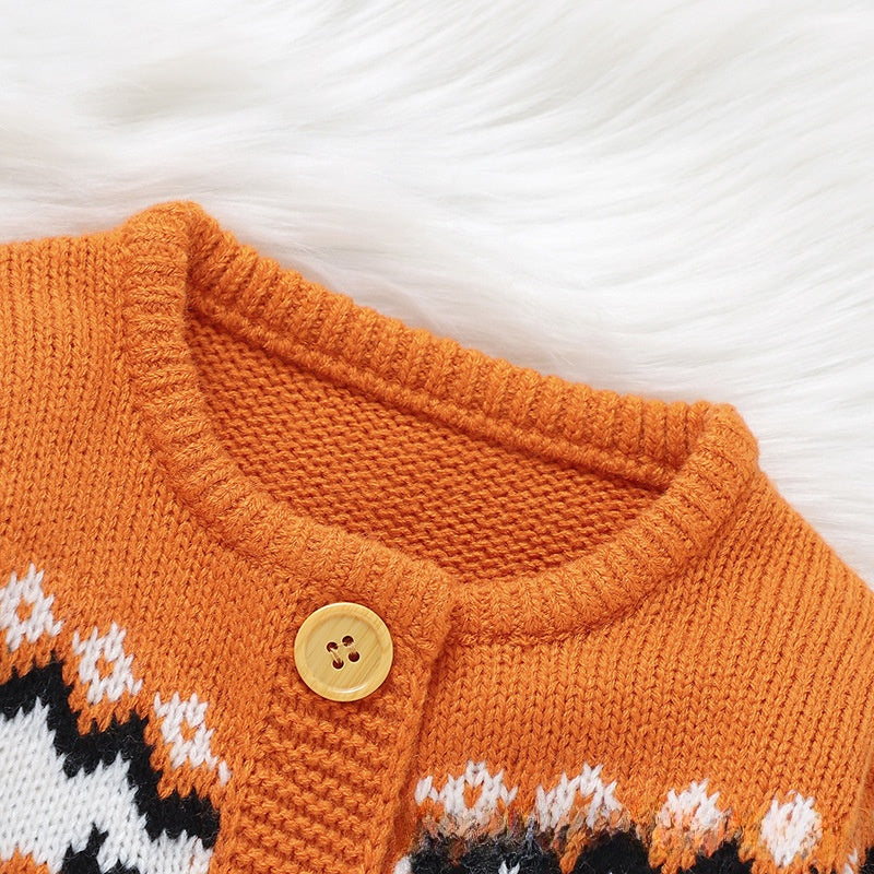 Close-up of an orange knit cardigan sweater with a gold button