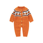 An orange knit baby cardigan romper with a Fair Isle style pattern featuring jack-o'-lanterns on the chest, gold buttons, and cable-knit leg panels, shown on a plain white background.